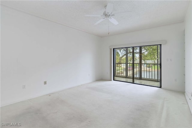 spare room featuring a textured ceiling, ceiling fan, and carpet flooring