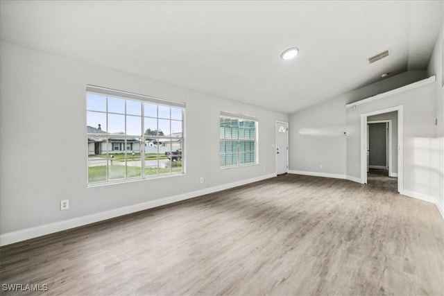 unfurnished living room with hardwood / wood-style flooring and lofted ceiling