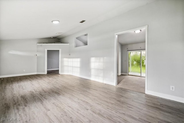 spare room featuring lofted ceiling and wood-type flooring