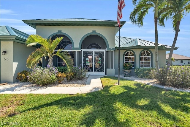 exterior space with french doors and a lawn