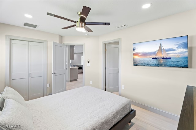 bedroom with ceiling fan, a closet, and light hardwood / wood-style flooring