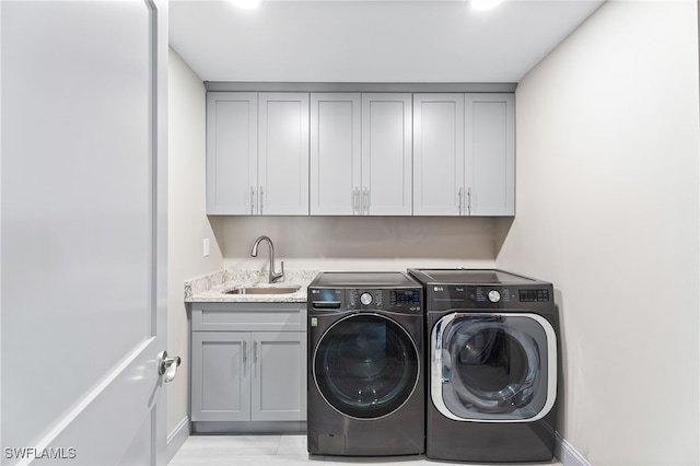 washroom featuring cabinets, sink, and washing machine and dryer