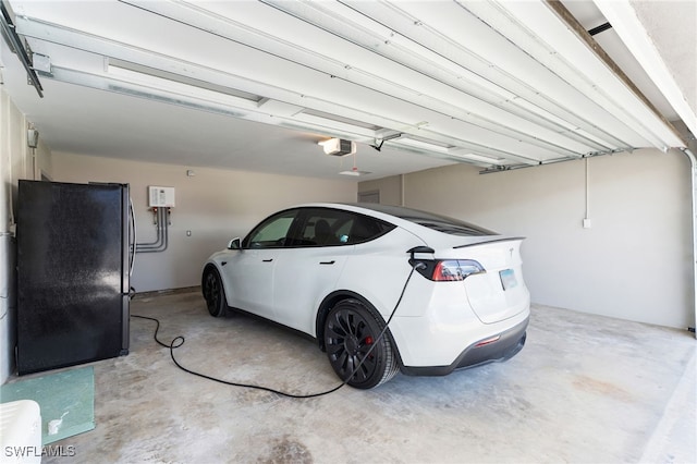 garage with black refrigerator and a garage door opener