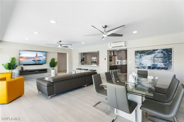 dining area featuring light hardwood / wood-style floors, an AC wall unit, and ceiling fan