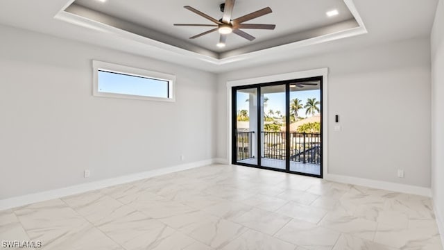 unfurnished room featuring ceiling fan and a tray ceiling