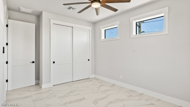 unfurnished bedroom featuring ceiling fan and a closet