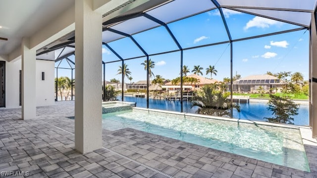 view of swimming pool featuring glass enclosure, a water view, an in ground hot tub, and a patio