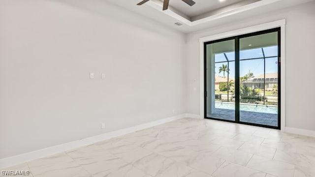 empty room with a tray ceiling and ceiling fan