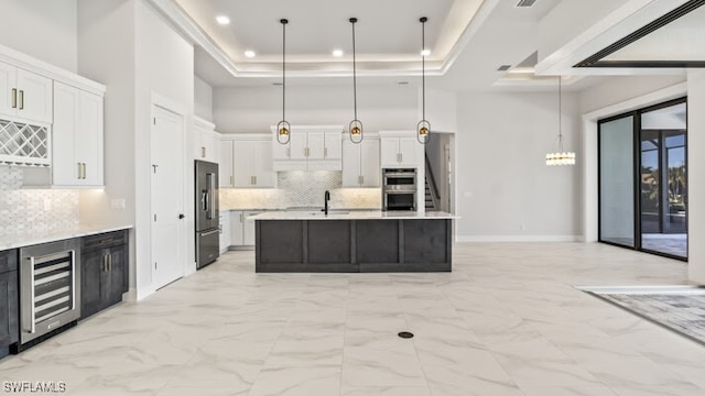 kitchen with backsplash, white cabinetry, decorative light fixtures, and appliances with stainless steel finishes