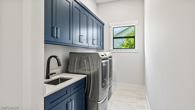 laundry room featuring washer and clothes dryer, sink, and cabinets