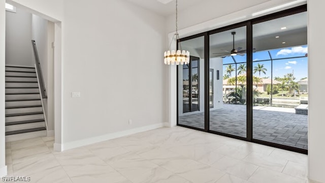 unfurnished room with ceiling fan with notable chandelier and floor to ceiling windows