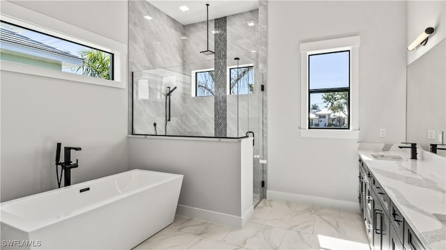 bathroom with separate shower and tub, vanity, and a healthy amount of sunlight