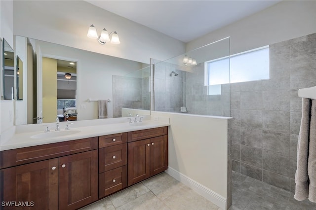 bathroom with a sink, double vanity, walk in shower, and connected bathroom