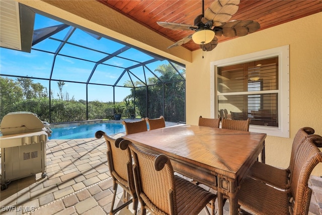 view of patio / terrace with outdoor dining area, grilling area, glass enclosure, ceiling fan, and an outdoor pool