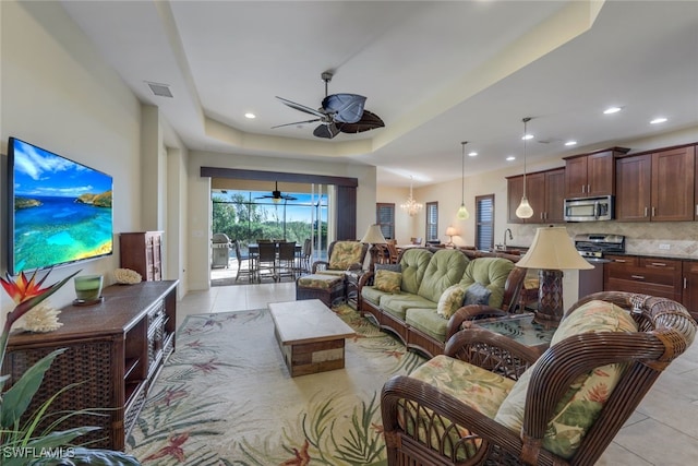 living area with recessed lighting, visible vents, a tray ceiling, and light tile patterned flooring