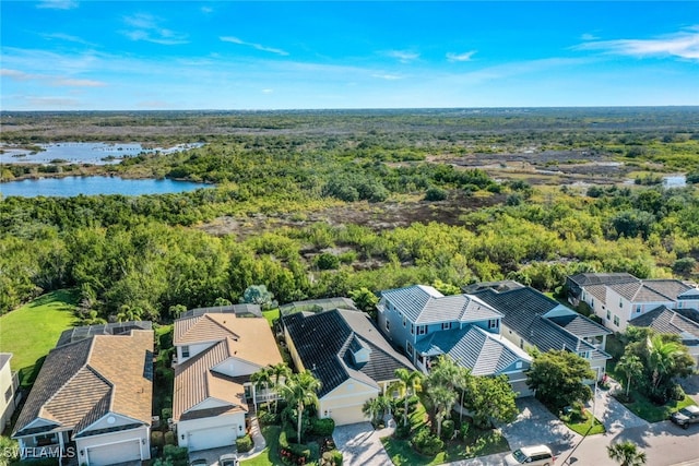 drone / aerial view with a residential view, a water view, and a forest view