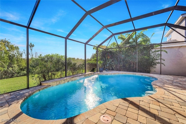 pool with glass enclosure and a patio