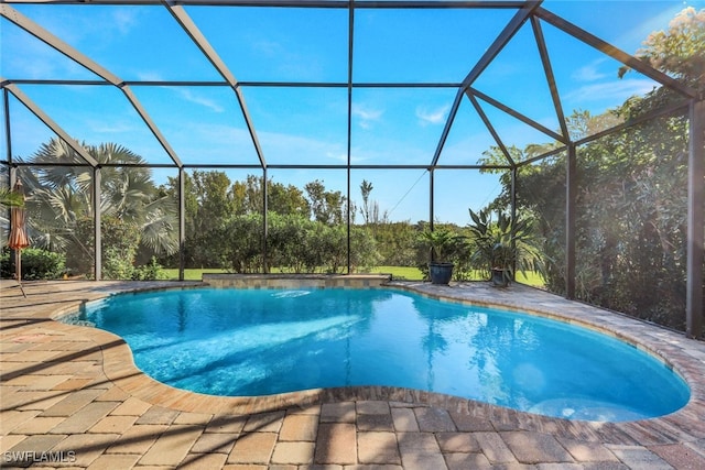 outdoor pool with glass enclosure and a patio area