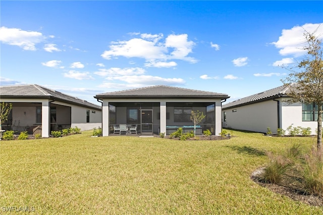 rear view of property with a sunroom and a lawn