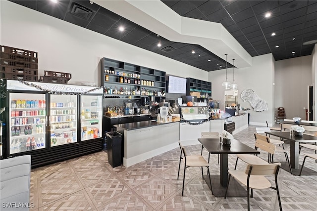 kitchen with a towering ceiling and hanging light fixtures