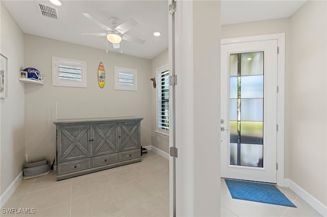 doorway with ceiling fan and light tile patterned flooring