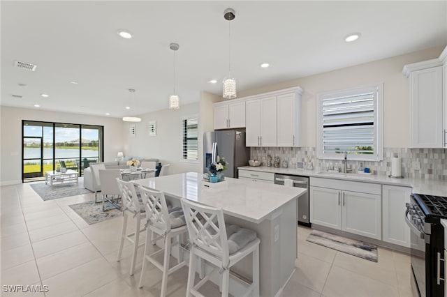 kitchen featuring white cabinetry, appliances with stainless steel finishes, sink, and pendant lighting