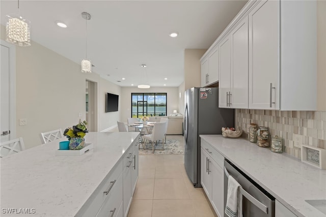 kitchen with white cabinetry, decorative light fixtures, light tile patterned floors, light stone countertops, and decorative backsplash