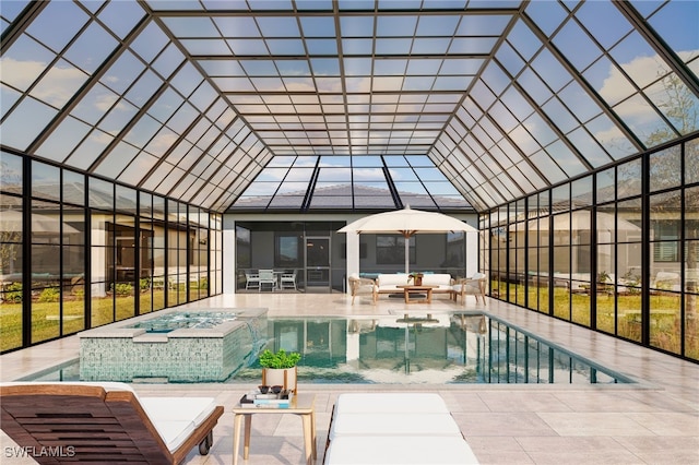 view of swimming pool featuring outdoor lounge area, a patio, glass enclosure, and an in ground hot tub