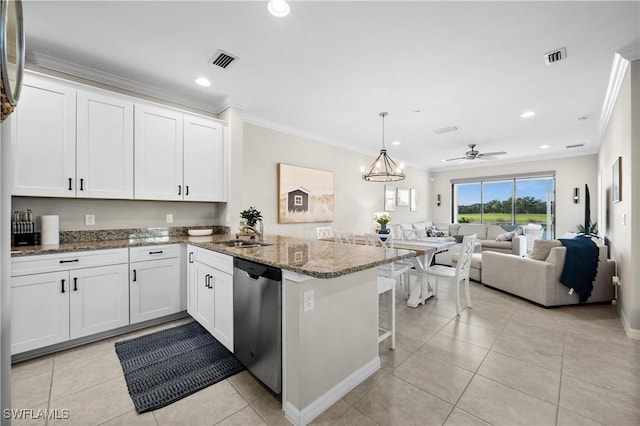 kitchen with stone counters, white cabinets, ceiling fan with notable chandelier, stainless steel dishwasher, and kitchen peninsula