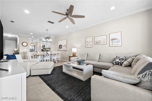 tiled living room with ceiling fan with notable chandelier and crown molding