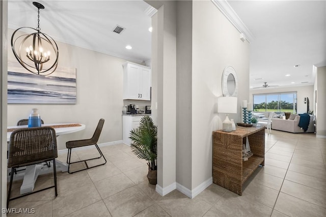 interior space featuring light tile patterned floors, ornamental molding, and a notable chandelier