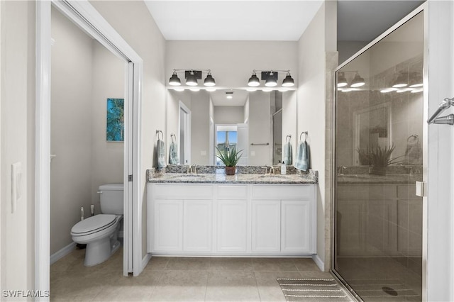 bathroom featuring tile patterned floors, vanity, toilet, and walk in shower