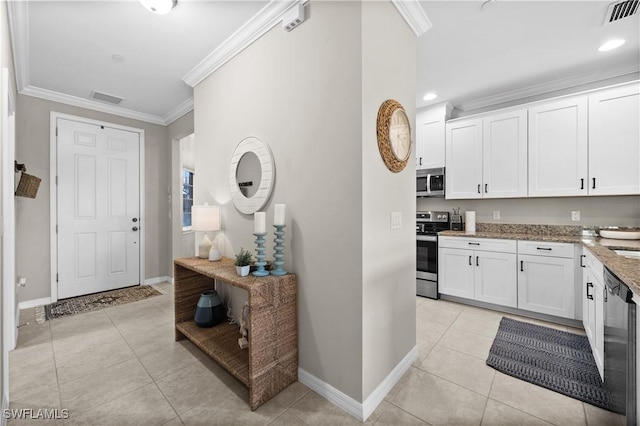 kitchen with white cabinetry, stainless steel appliances, light stone counters, crown molding, and light tile patterned floors