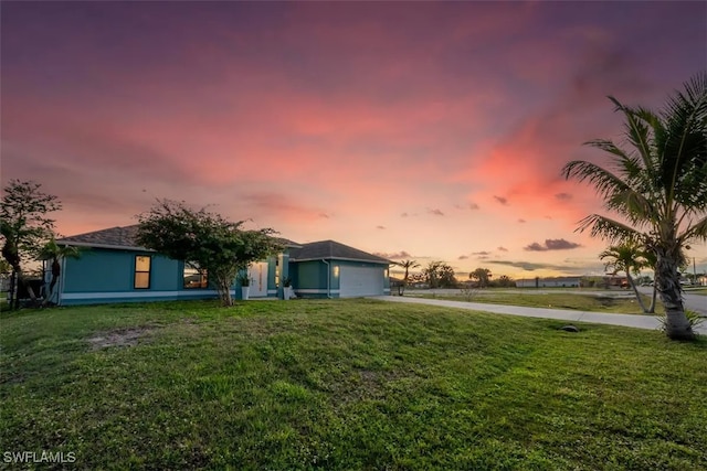 view of front of property featuring a garage, a yard, and driveway