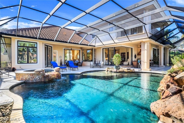 view of pool with a lanai, a patio area, and an in ground hot tub