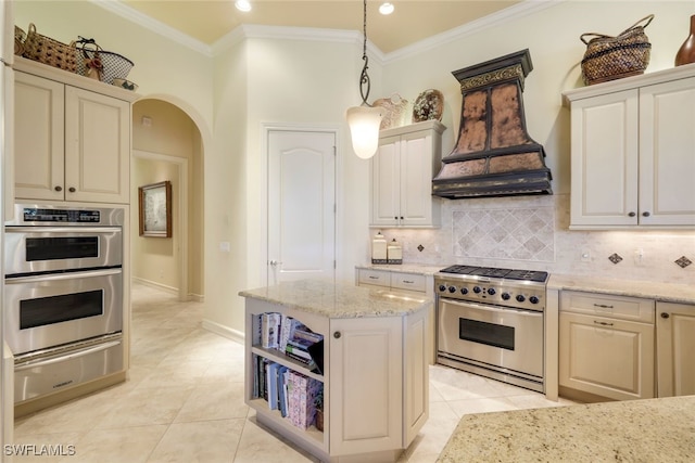 kitchen with light stone countertops, stainless steel appliances, decorative light fixtures, and custom exhaust hood