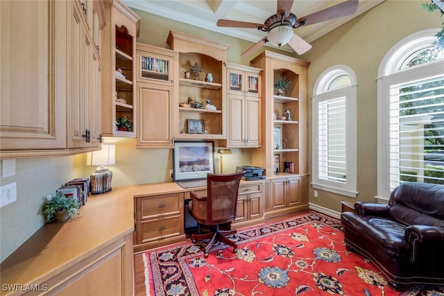 office space featuring beam ceiling, built in desk, ceiling fan, and crown molding