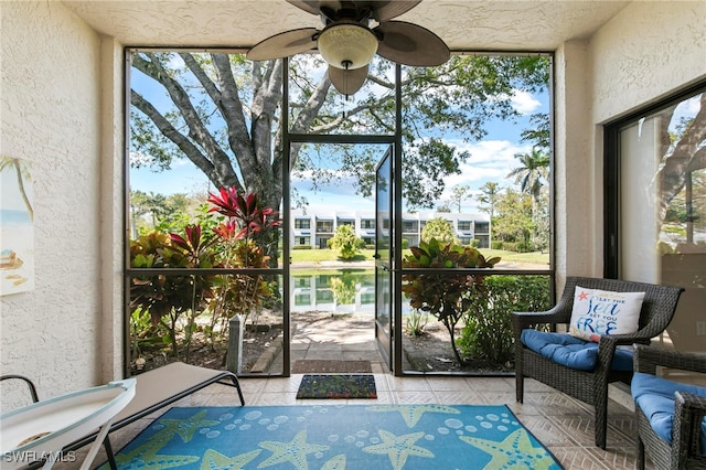 sunroom / solarium featuring a water view, a wealth of natural light, and ceiling fan