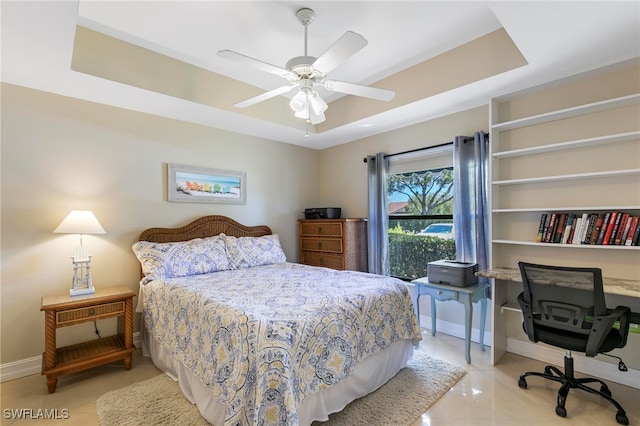 bedroom featuring light tile patterned floors, a raised ceiling, and ceiling fan