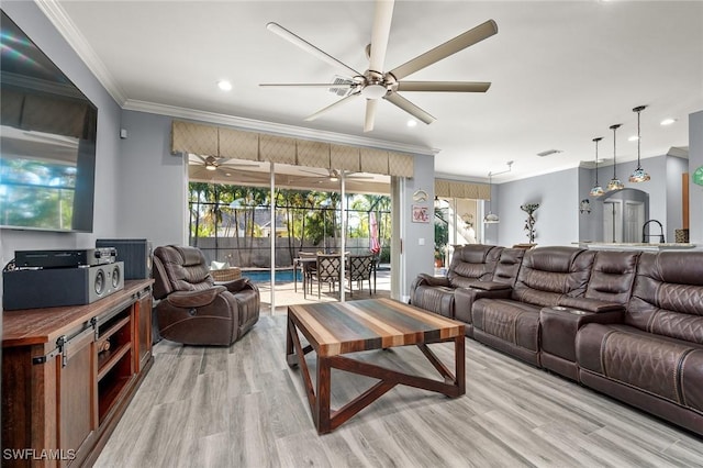 living room with plenty of natural light, ceiling fan, ornamental molding, and light hardwood / wood-style flooring