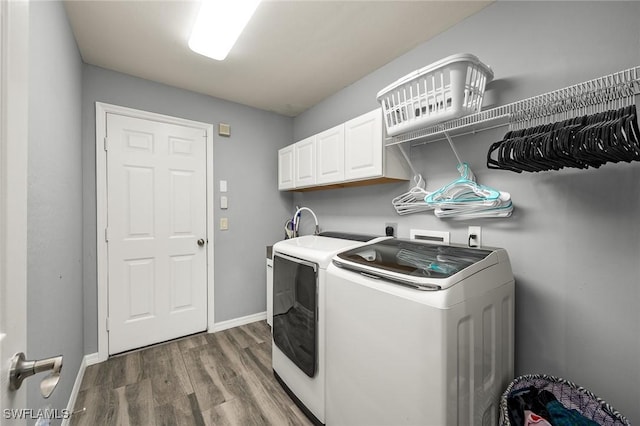 laundry room featuring cabinets, dark hardwood / wood-style floors, and independent washer and dryer