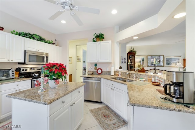 kitchen featuring a center island, stainless steel appliances, white cabinetry, and sink