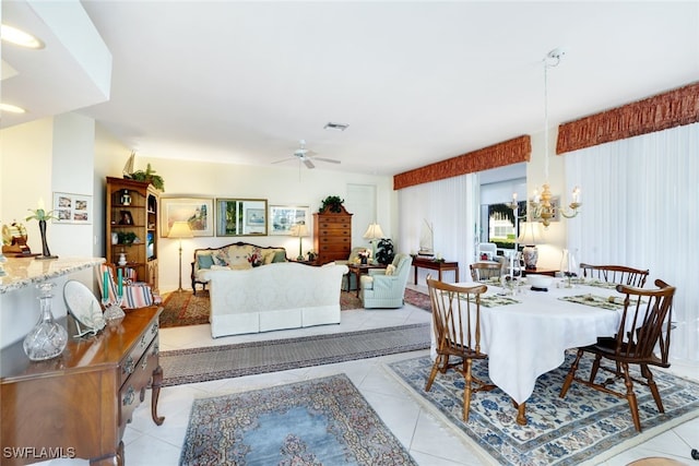 tiled dining space with ceiling fan with notable chandelier