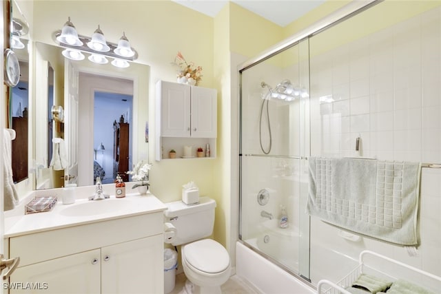 full bathroom featuring combined bath / shower with glass door, vanity, and toilet