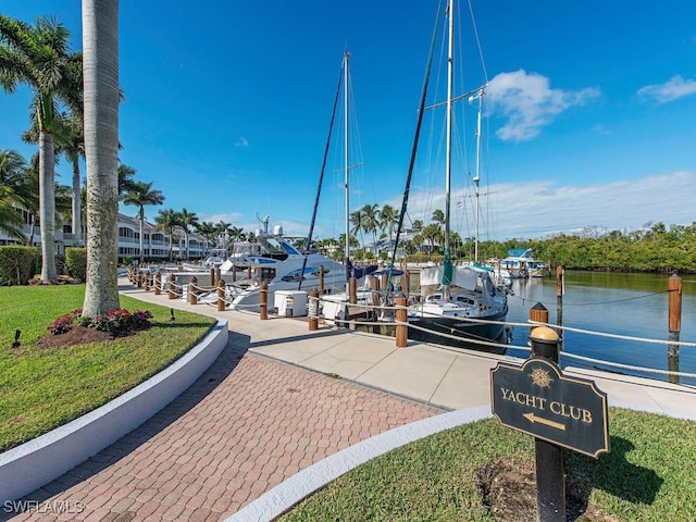 view of dock featuring a lawn and a water view