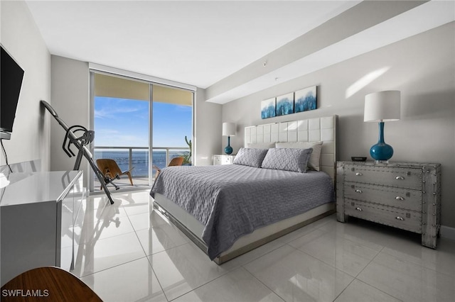 tiled bedroom featuring access to outside, a water view, and expansive windows