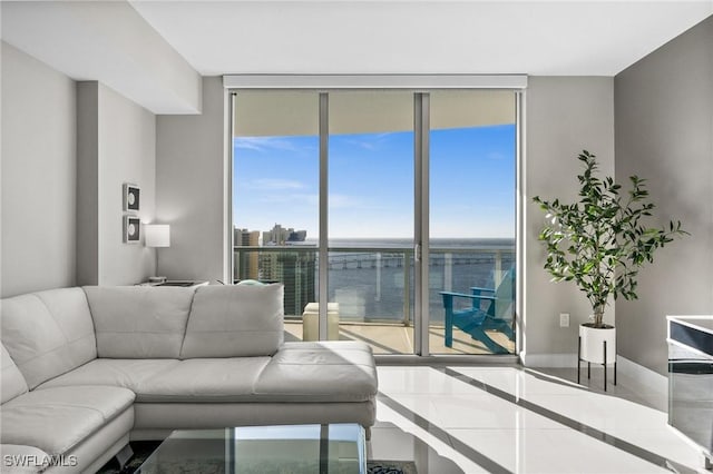 tiled living room featuring floor to ceiling windows and a water view