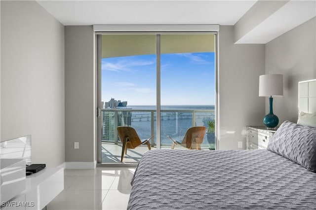 tiled bedroom with access to exterior, a water view, and multiple windows