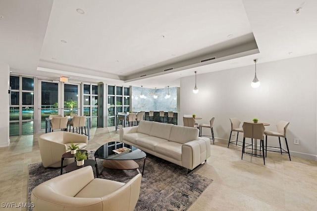 living room featuring french doors and a tray ceiling