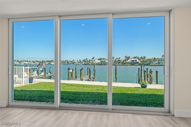 doorway to outside with hardwood / wood-style flooring and a water view